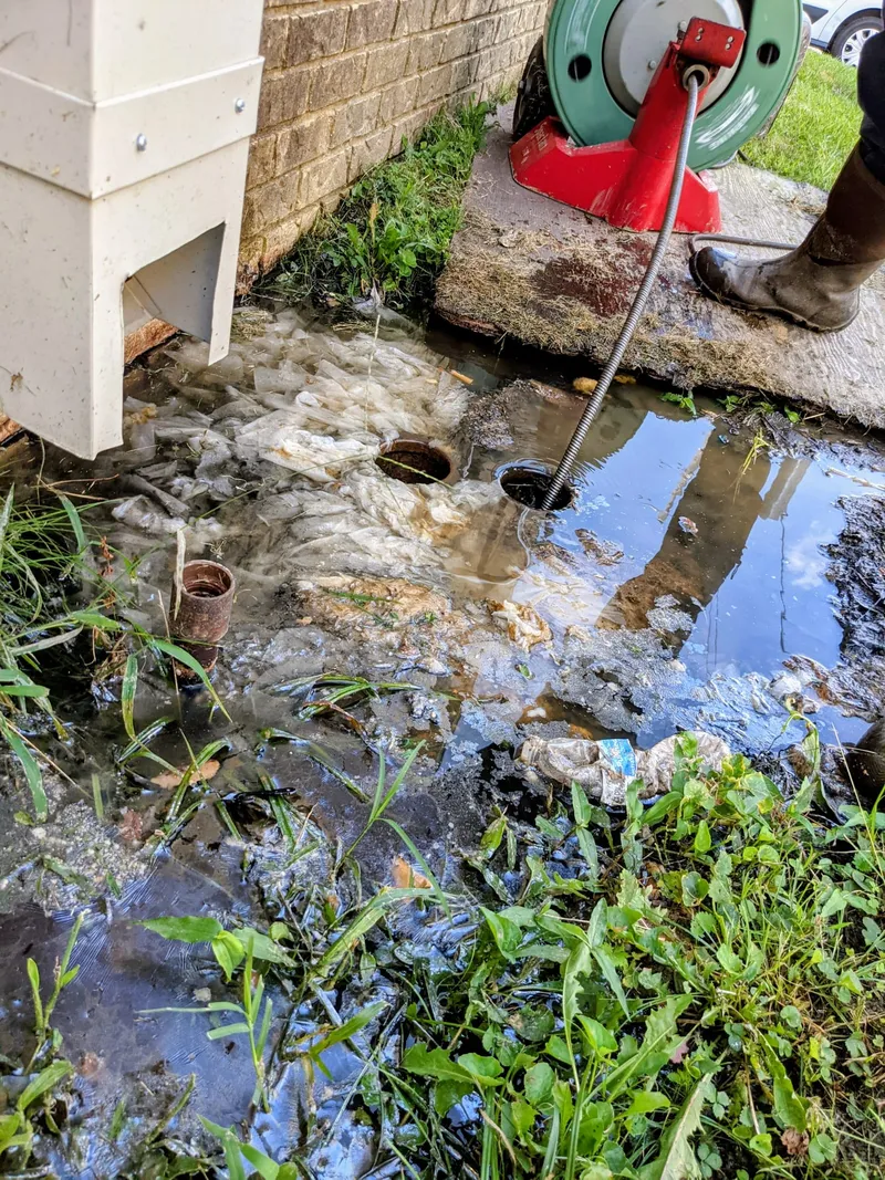 Drain cleaning with a sewer snake outside a building near UALR - sewage backup cleared at the clean-out