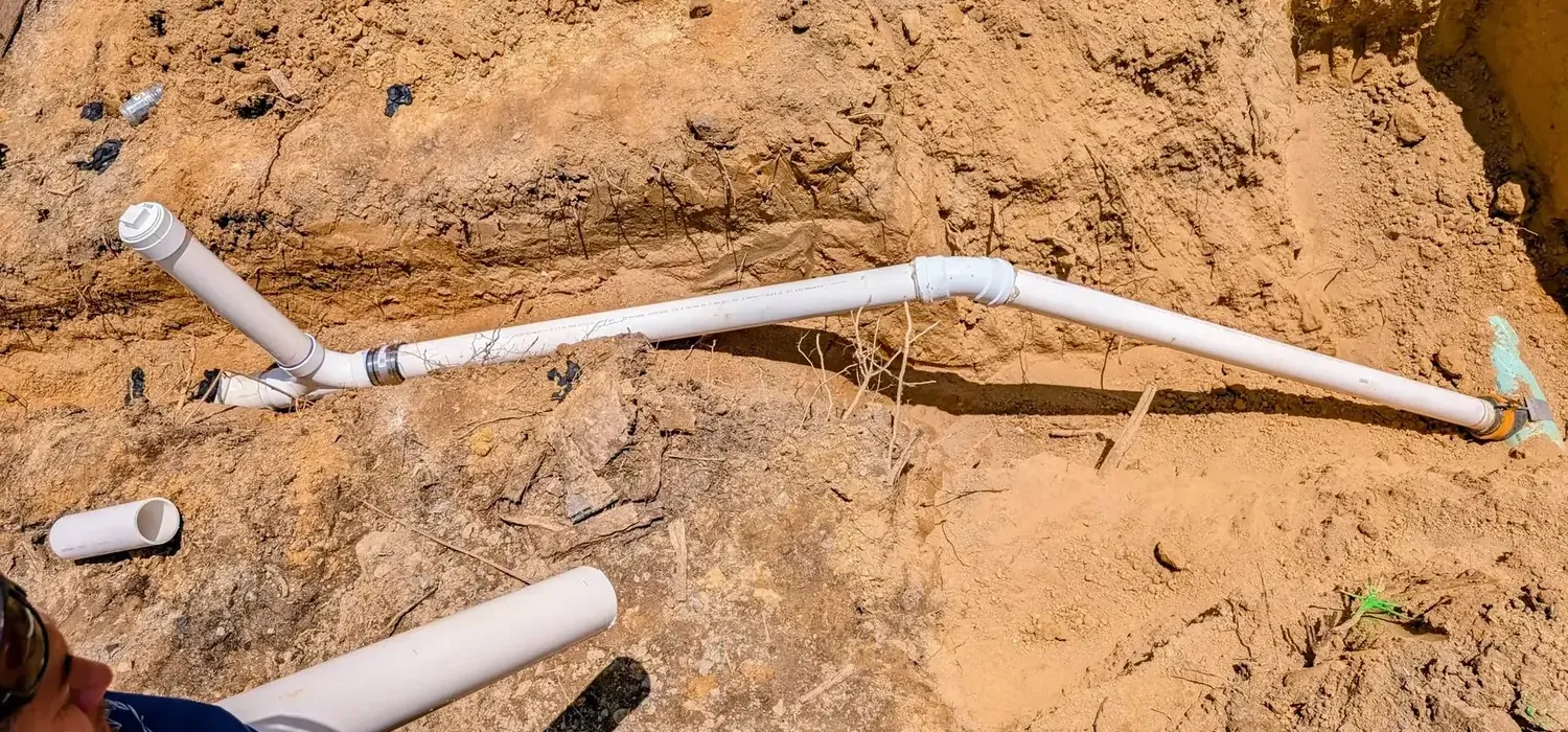 Excavated trench with old and new water service lines