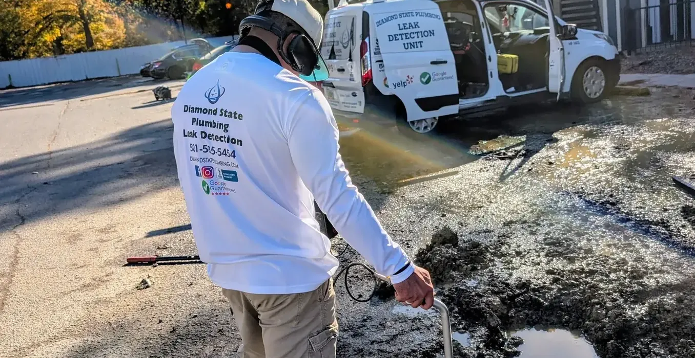 Active water leak spraying from an exposed underground pipe connection