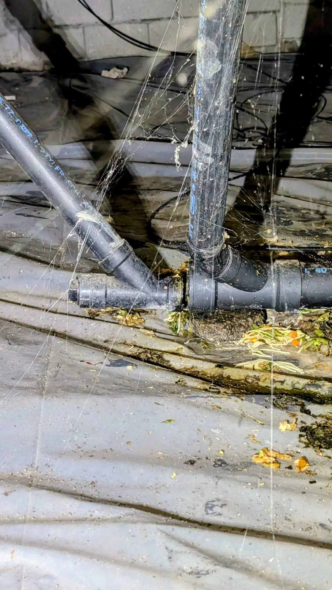 Aging drain line under a Pleasant Valley home's crawl space where the pipe broke and needed repair