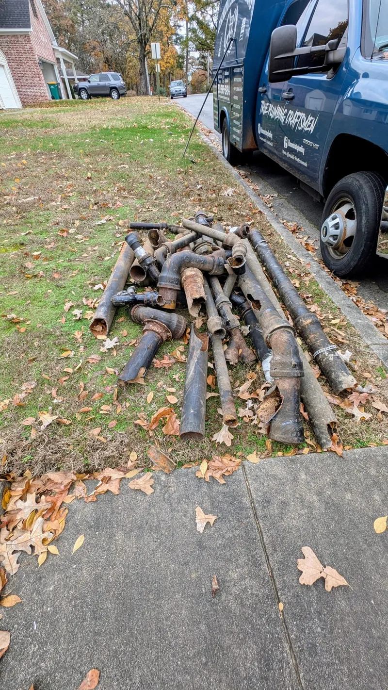 Old rusted and leaking drain lines removed during a full replumb in a Cammack Village home
