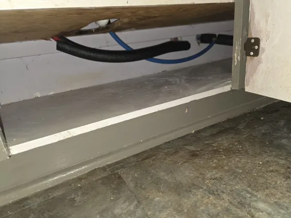 New insulated water supply lines installed behind a cabinet base