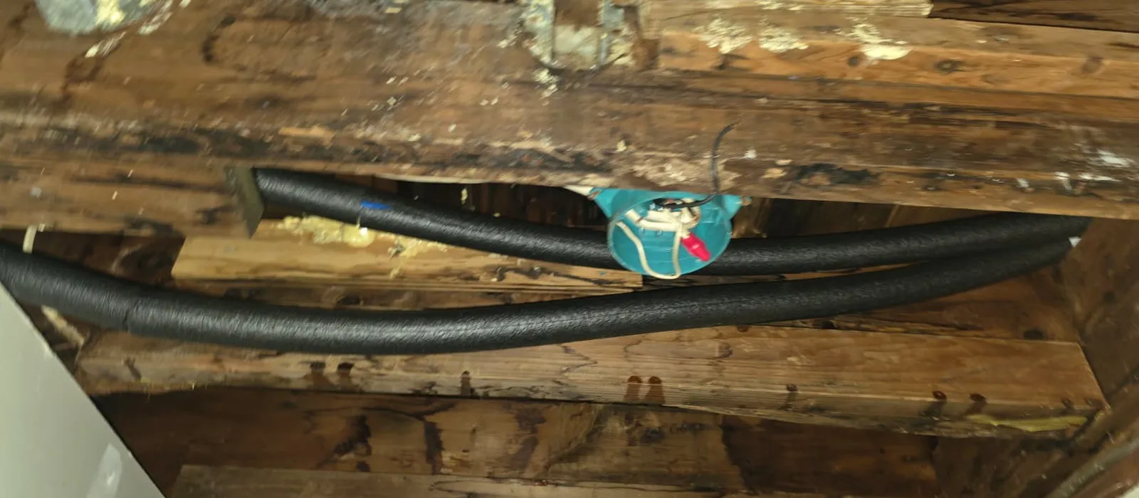 Insulated PEX water lines routed under a floor during a repipe