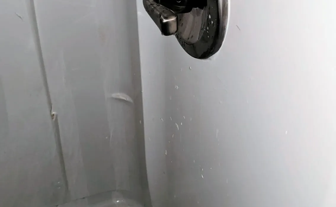 Diamond State Plumbing technician completing a custom shower installation with rain head