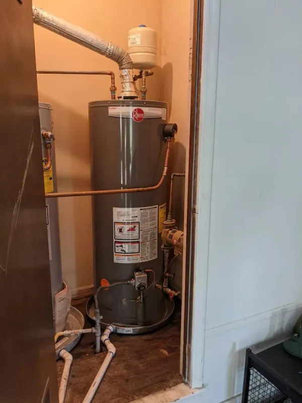 Tank water heater installed in a utility closet