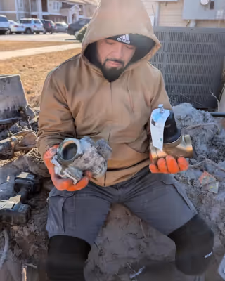 Diamond State Plumbing crew member displaying old corroded pipes