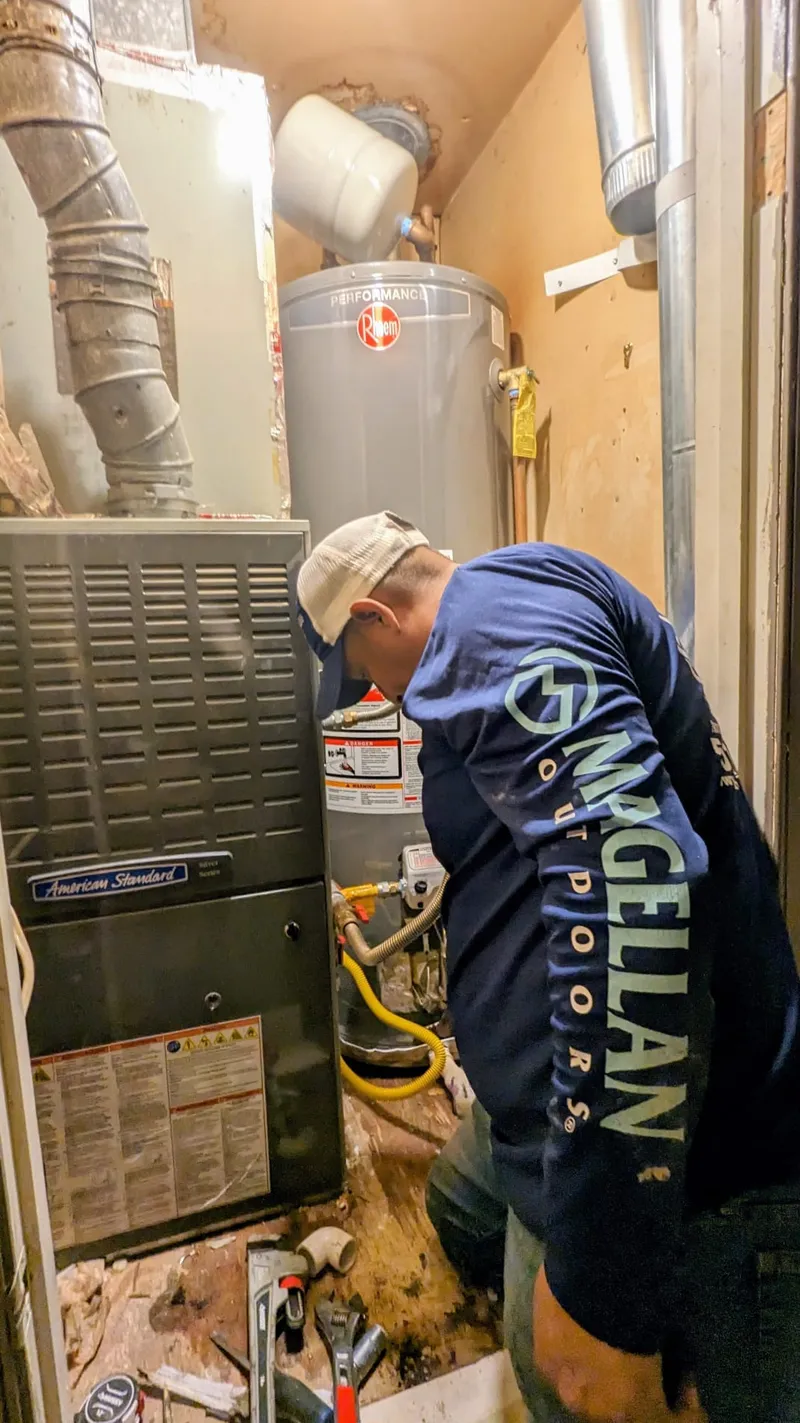 Water heater brought up to code in a Cammack Village mechanical room -´ fresh air intake pipes added for combustion air, expansion tank installed for thermal expansion protection, and emergency shut-off valve relocated within the required 2-ft range