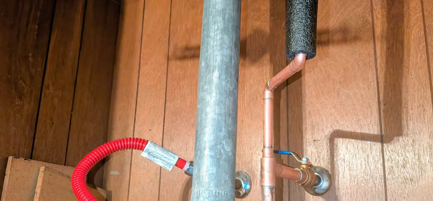 Tank water heater installed in a utility closet