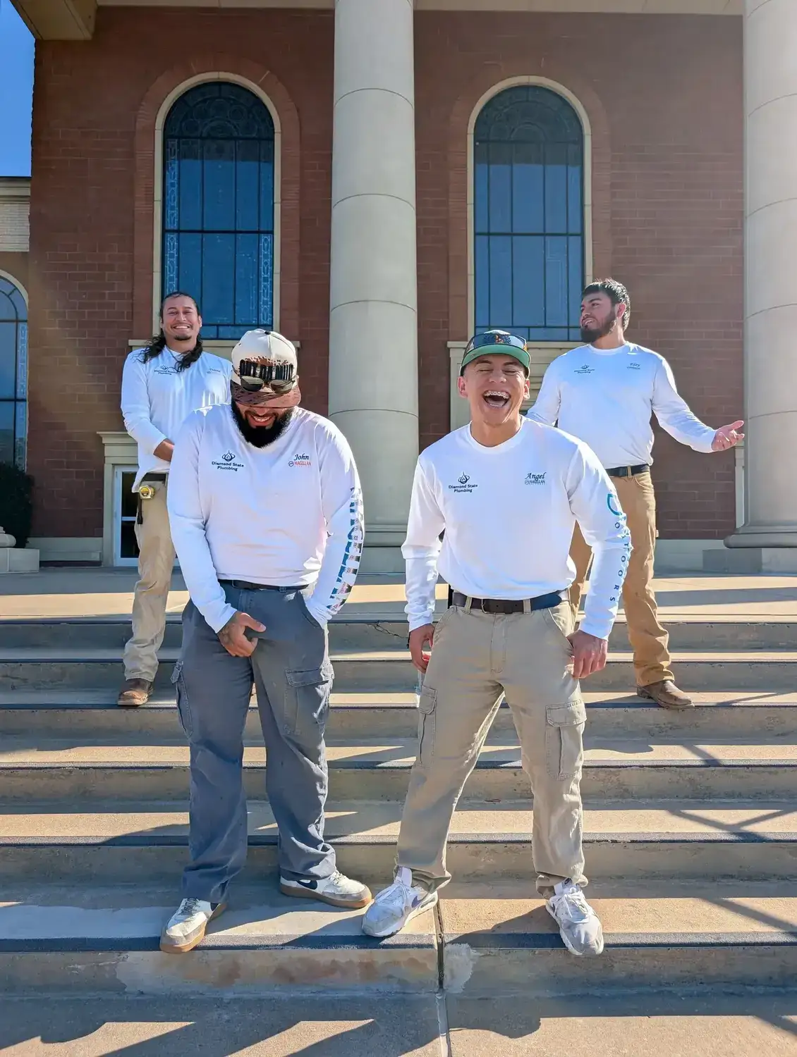 Diamond State Plumbing crew standing on steps of brick building