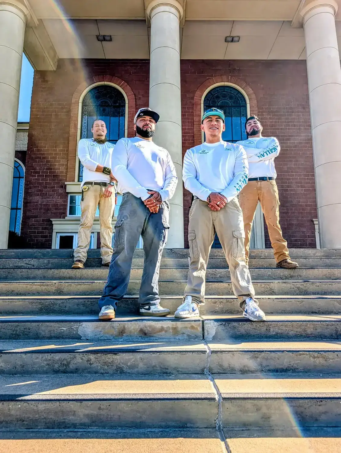 Diamond State Plumbing crew standing on steps of brick building